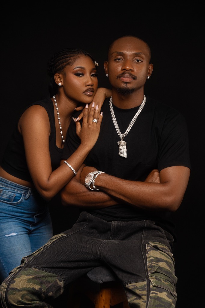 MYLUX couple wearing iced chains, signature pendant, luxury timepiece, and diamond jewelry.